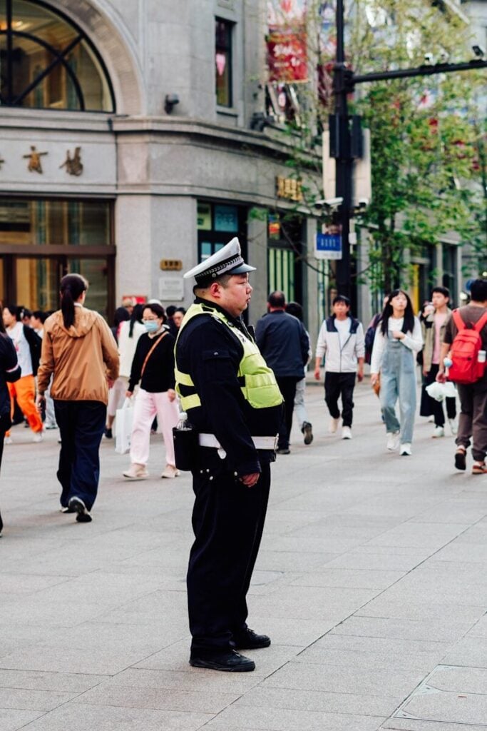 A traffic police officer stands on a busy city street